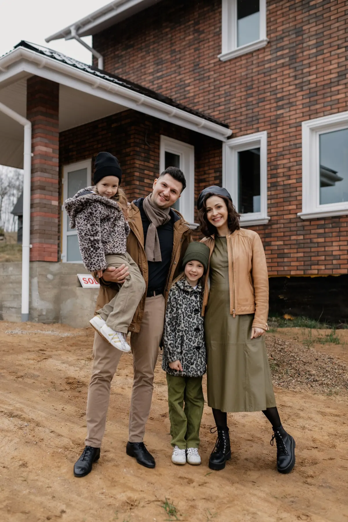 Happy family in front of their brick home after electrical service