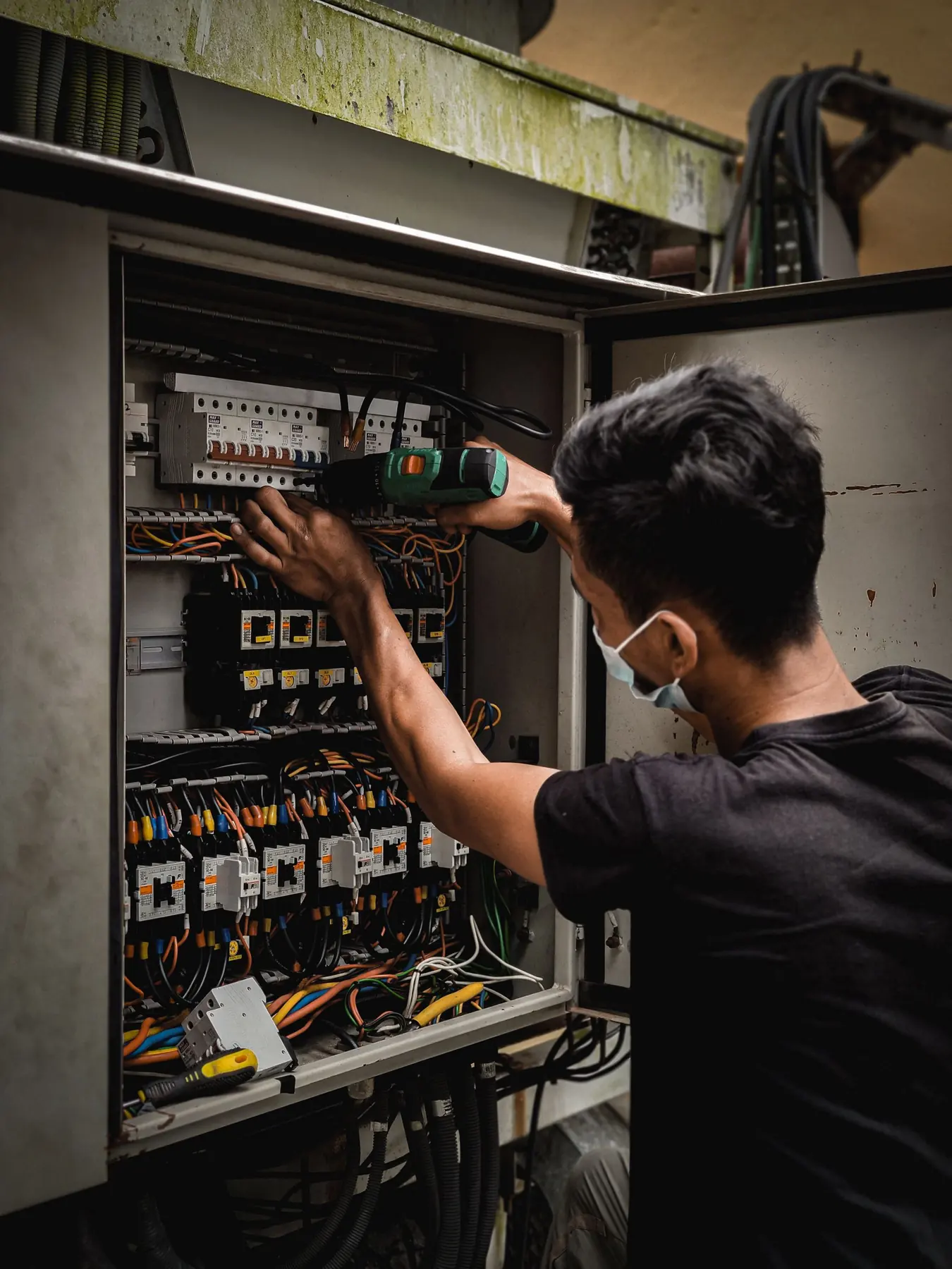 Industrial electrician wiring a control panel